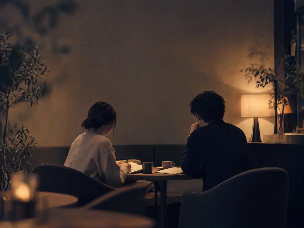 カフェで静かに語り合う2人